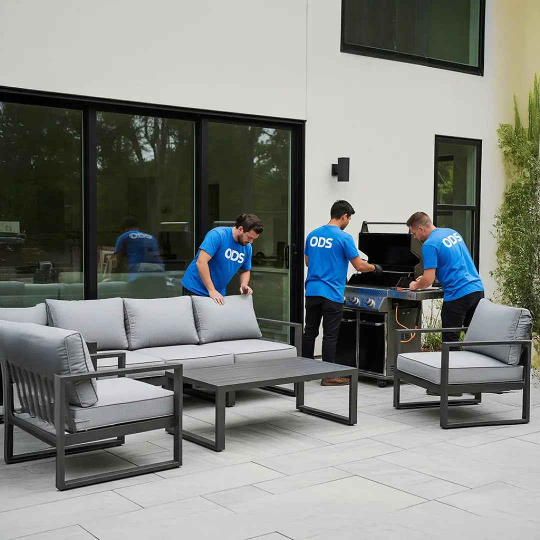 Three men in blue shirts with 'ODS' logos working on outdoor furniture.